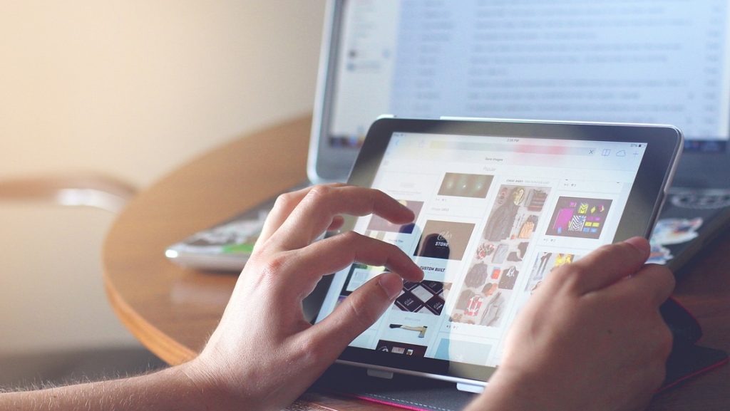 Tablet and laptop in background.