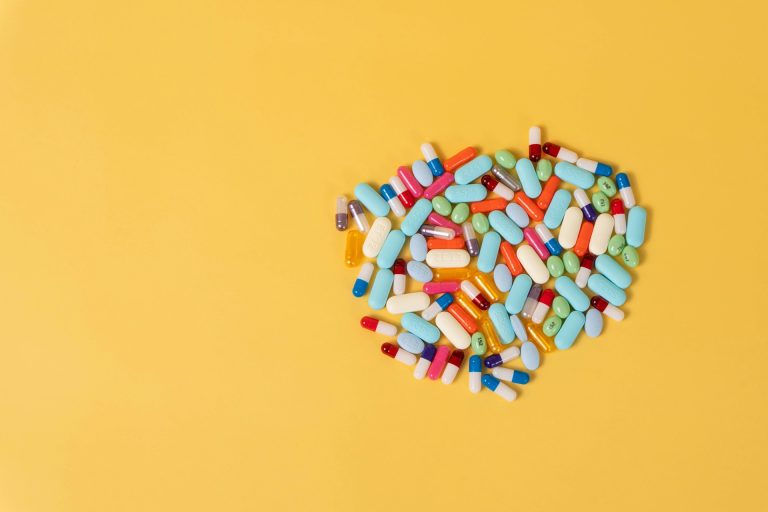 Colorful pills on yellow background