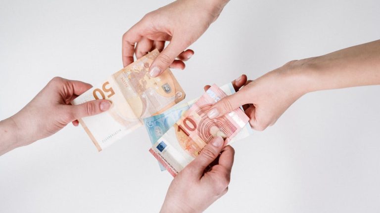 Two pairs of hands exchanging money (euros)