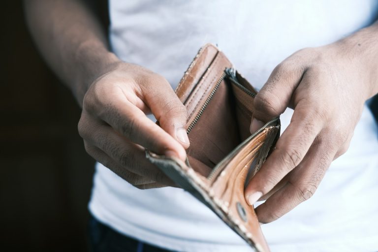 Man holding an empy open wallet