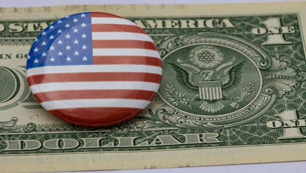 US button on top of a dollar bill