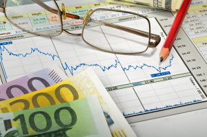 Euro banknotes, glasses and graphs