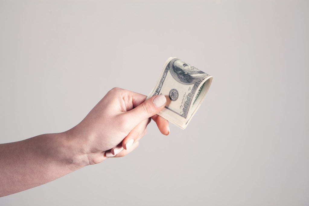 Hand holding out dollar bill
